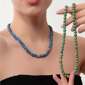 Détail de colliers en perles de verre Millefiori faits main aux motifs de vagues colorées