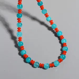Sommerliche Boho-Halskette mit blauen Perlen und leuchtend orangen Zwischenperlen