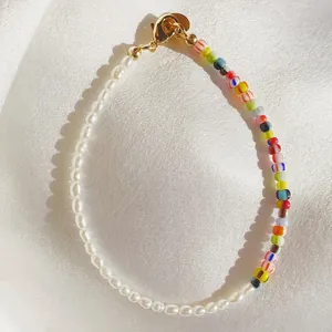 Detailed shot of glass beads and natural pearls bracelet on white silk background