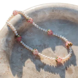Collier artisanal avec perles d'eau douce et breloques fraises roses en verre