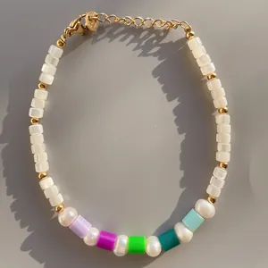 Dettaglio di bracciale con perline colorate in pietra naturale e catena di estensione dorata