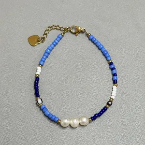 Blue and white glass bead bracelet with natural pearls and golden heart pendant charm