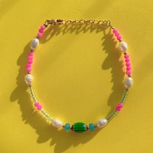 Macro view of colorful beaded bracelet with natural pearls and green glass bead center