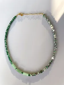 Detail of beaded necklace with green natural stones, freshwater pearls and gold clasp
