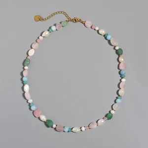 Close-up of handmade beaded necklace with baroque pearls and pink and green stones