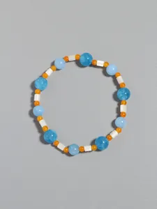 Detailed macro view of blue and orange natural stone beads with white shell spacers