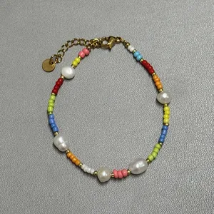 Detailed close-up of colorful glass beads and freshwater pearls on a handmade bracelet
