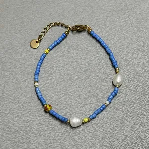 Detailed macro view of colorful glass beads and natural freshwater pearls on a gold chain