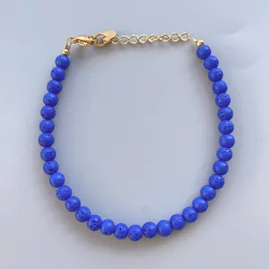 Dettaglio del bracciale con perline di pietra lavica blu e chiusura a moschettone dorata