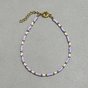 Detail of lavender and white glass beads with freshwater pearls and gold lobster clasp