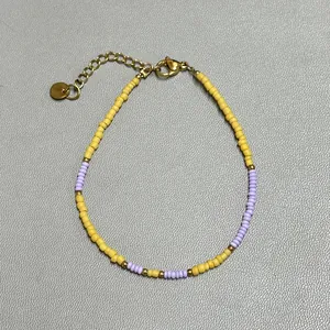 Detail view of colorful glass beads and freshwater pearl bracelet with golden clasp