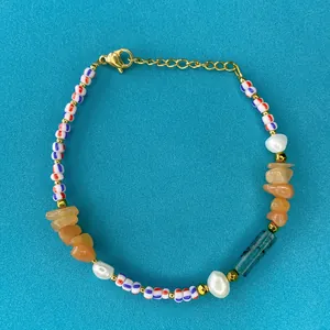 Dettaglio di perline in pietra naturale e perle d'acqua dolce su un bracciale boho