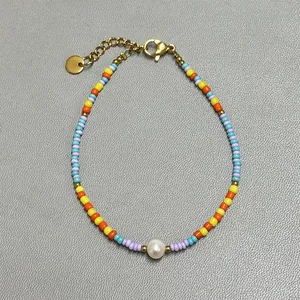 Detail of colorful bohemian beaded bracelet with freshwater pearl and gold lobster clasp