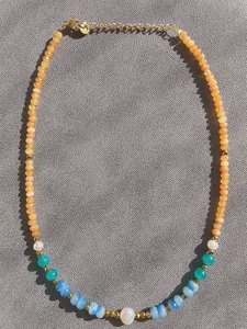 Detail of colorful beads and freshwater pearls on a handmade beaded necklace with gold clasp
