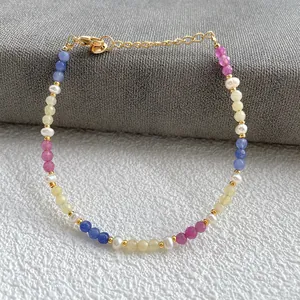 Macro detail of colorful gemstones and freshwater pearls on a gold plated bracelet