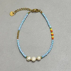 Detailed view of colorful glass beads and freshwater pearls on an adjustable bracelet