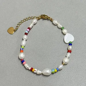 Detail of colorful glass beads and freshwater pearls bracelet with gold heart charm