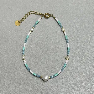 Detail of a handmade beaded bracelet with freshwater pearls and blue glass beads