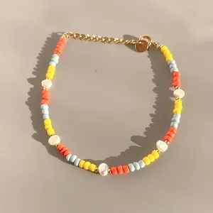 Macro shot of colorful glass beads and freshwater pearl bracelet with gold clasp
