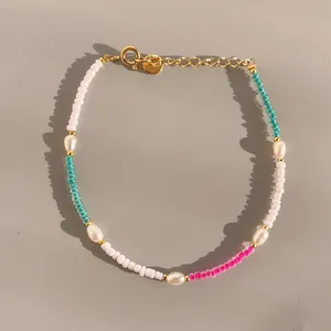 Detail of colorful beads and freshwater pearls on a gold clasp adjustable bracelet