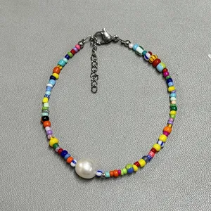 Detailed shot of handmade colorful beaded bracelet with a large white central pearl accent