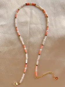 Nahaufnahme der 18k vergoldeten Schließe und bunten Steinperlen auf Seidenhintergrund