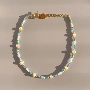 Detail of colorful beads and freshwater pearls with gold lobster clasp and extension chain