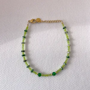 Detail of green glass beads and freshwater pearl bracelet with gold adjustable chain