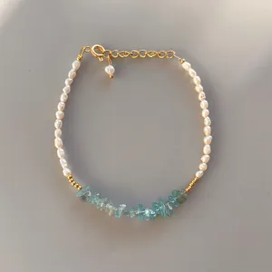 Detail of freshwater pearl bracelet with light blue gemstones and golden adjustable clasp