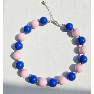 Collana di perline blu e rosa con chiusura a moschettone in argento su sfondo bianco