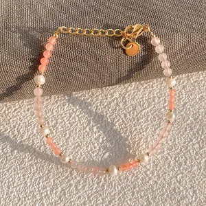 Macro shot of freshwater pearls and pink natural stones with a gold-tone lobster clasp