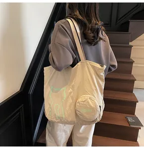 Detail of beige canvas tote bag featuring green cat print and mini round coin purse