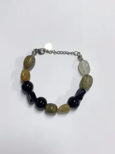 Detail of beaded bracelet with natural stone, silver heart charm and lobster clasp
