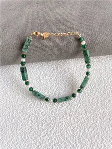 Detalle de piedras naturales verdes y perlas de agua dulce en pulsera hecha a mano