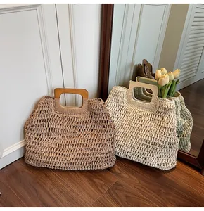 Détail de sacs de plage en paille tressée avec poignées rectangulaires en bois bicolores
