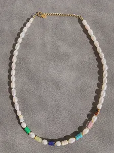 Detail of colorful beads and freshwater pearls necklace with gold adjustable chain