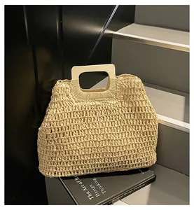 Détail d'un sac de plage en paille tissé main avec maille texturée et anse en bois