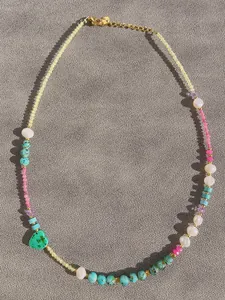 Detail of colorful gemstone and pearl necklace with a green marble heart pendant