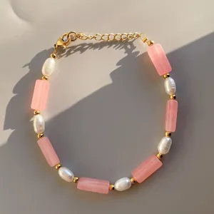 Detalle de pulsera de cristal rosa y perlas de agua dulce con cierre de langosta dorado