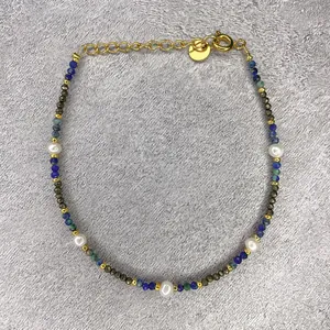 Detail of handmade freshwater pearl bracelet with colorful faceted beads and gold clasp