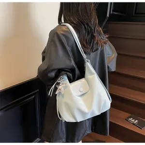 Detailed view of light blue pleated hobo bag with a silver star charm on model
