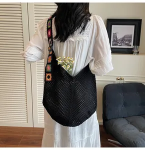 Detailaufnahme der schwarzen Häkeltasche mit bunt besticktem Blumenschultergurt