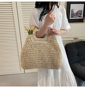 Détail du sac en paille avec poignée carrée en bois et texture tissée élégante