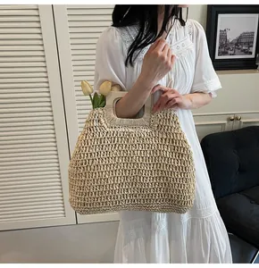 Détail du sac à main en paille tressée avec poignées carrées en bois naturel