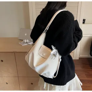 Detail of off-white faux leather tote bag with silver star charm and button pocket