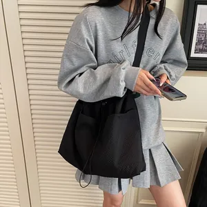 Black nylon tote bag with drawstring pockets and minimalist casual style for daily use