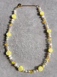 Detail of freshwater pearl necklace with lemon beads, lobster clasp and heart pendant