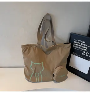 Detail of khaki nylon tote bag featuring cat print and a round detachable zipper pouch