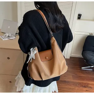 Close-up of caramel PU leather shoulder bag with magnetic flap and silver star charm