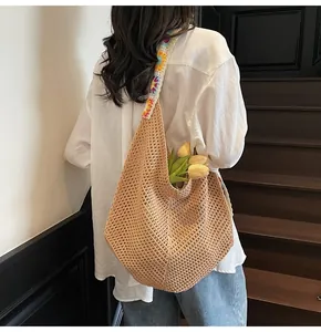 Detail der Häkeltasche mit buntem Blumengurt und gewebter Textur auf einer Treppe